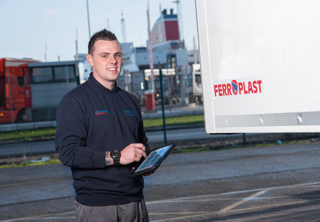 Technician at Belfast Port Commercials using Freeway Fleet Systems on a tablet whilst doing a completing a digital job card as part of a trailer service